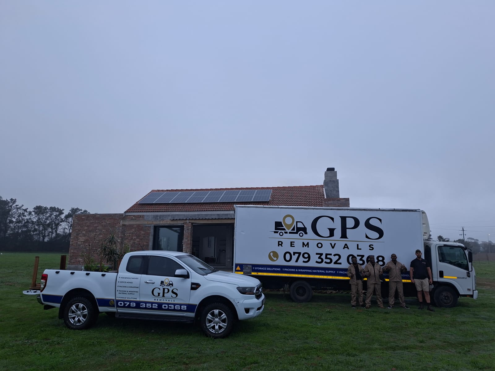 GPS Removals truck and bakkie on a grass plot beside a farmhouse