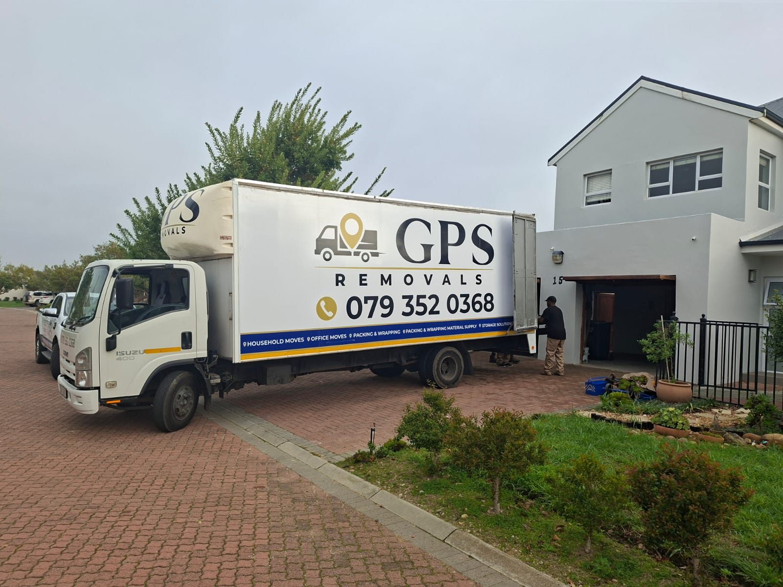 GPS Removals truck parked in a driveway while a mover unloads